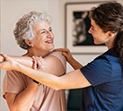 Nursing staff helping resident stretch arms