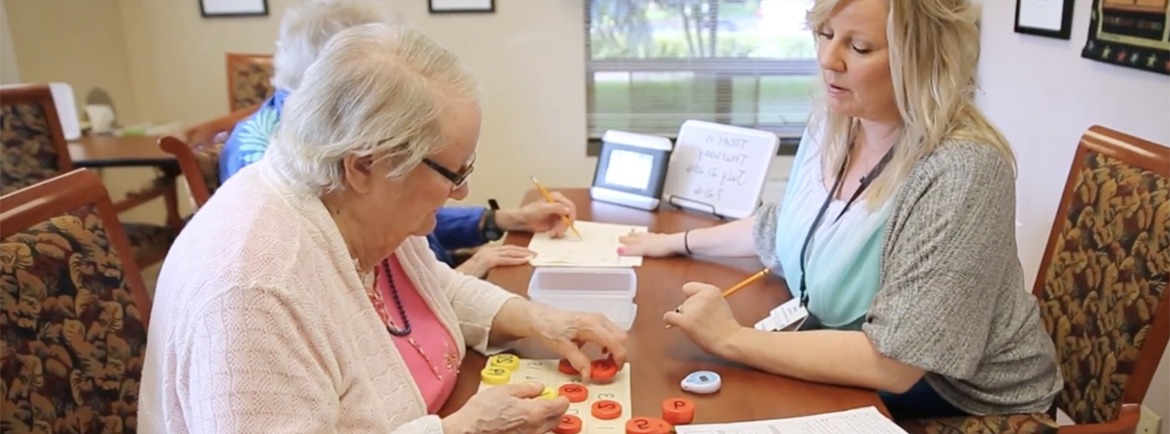 Woman helping elderly lady in memory games
