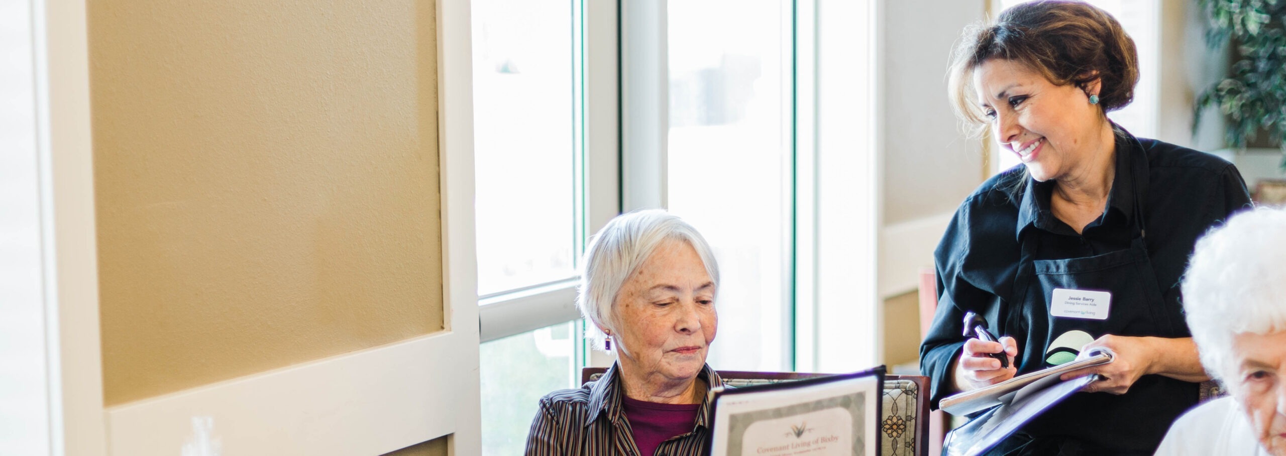 Waitress taking the order or elderly woman in dining area