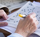 Hand filling out crossword