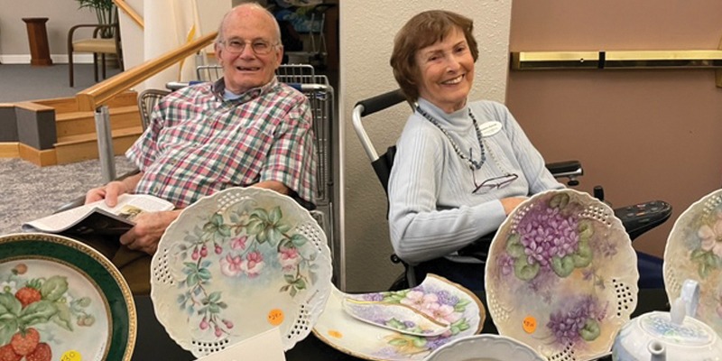Couple sitting in front of painted plates
